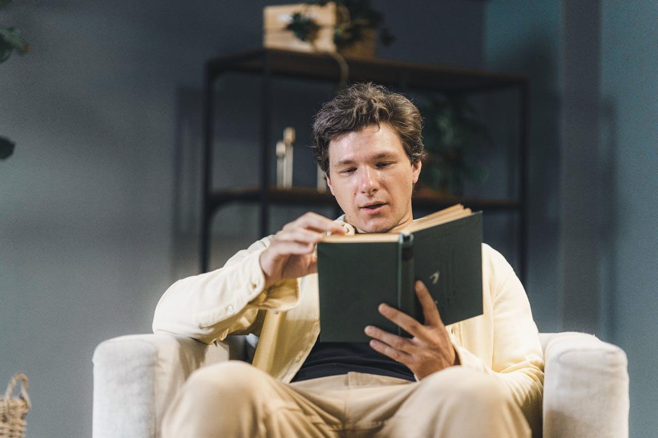 Człowiek czyta książkę w fotelu